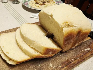Нарезанный ломтями белый хлеб на деревянной доске