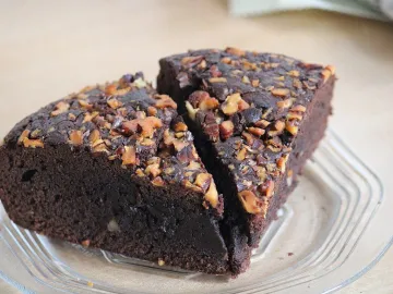 Кусочки брауни с рублеными орехами на стеклянной тарелке