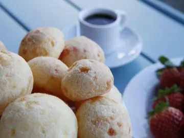 Бразильские сырные булочки пан ди кейжу рядом с чашкой кофе
