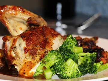 Запечённая куриная ножка с брокколи на белой тарелке
