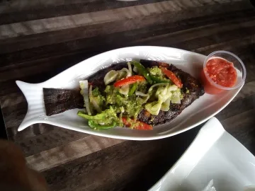 Запечённая рыба с овощами на белом блюде
