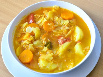 Тарелка густого капустного супа с морковью и картофелем