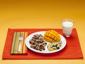 Тарелка с рисом и бобами, манго, кабачками и стакан молока