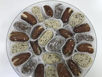 Финики с миндалём, в кунжуте и кокосовой стружке на подносе
