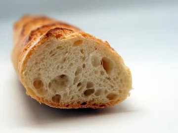 Разрезанный багет с пористым мякишем и румяной коркой