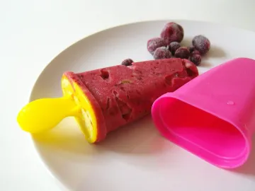 Ягодное эскимо на палочке рядом с формочкой и замороженной вишней