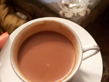 Чашка густого горячего шоколада на блюдце