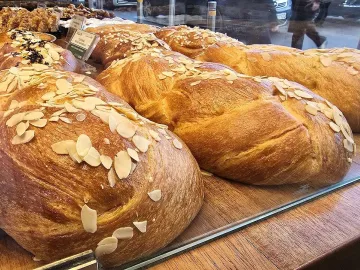 Плетёные греческие цуреки с миндальными лепестками на витрине