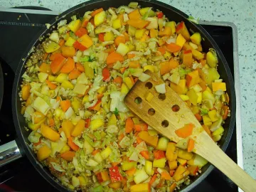 Гречка с капустой, тыквой и морковью на сковороде с лопаткой