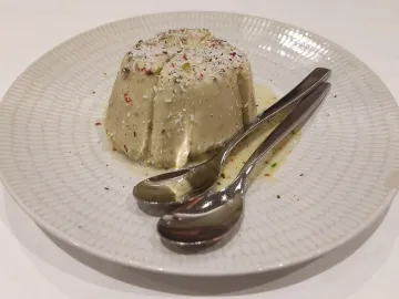 Фисташковое кульфи с кокосовой стружкой на белой тарелке