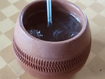 Канчанчара в глиняной чашке с трубочкой на столе