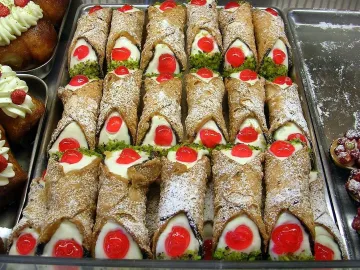 Сицилийские канноли с рикоттой, вишней и фисташками на подносе