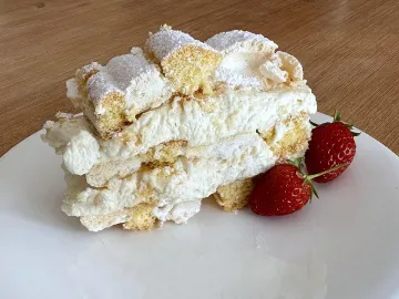 Кусок кардинальского пирожного со сливками и клубникой на тарелке