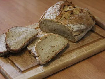 Домашний картофельный хлеб, целая буханка и нарезанные ломти на доске