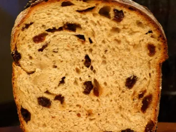 Разрез буханки хлеба с изюмом, видны ягоды и пористый мякиш