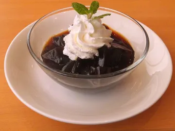 Кубики кофейного желе со взбитыми сливками и мятой в стеклянной миске