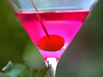 Розовый коктейль Роза с вишней на шпажке в бокале для мартини