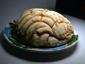 Мексиканская булочка конча с узорчатой сахарной корочкой на тарелке