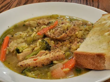 Куриный суп с рисом, брокколи, морковью и ломтиком хлеба