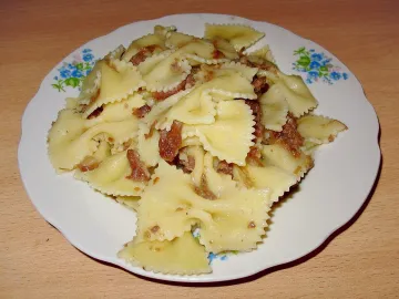 Макароны-бантики с обжаренным мясом на тарелке