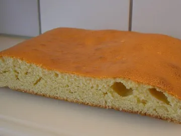 Разрезанный манник с румяной корочкой на белой доске