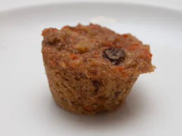 Морковный маффин с изюмом на белой тарелке