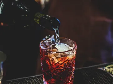 Игристое вино наливают в стакан с Кампари, вермутом и льдом
