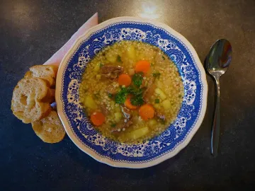 Тарелка перлового супа с говядиной, морковью и картофелем
