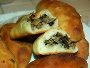 Разломленные пирожки с начинкой из фарша и грибов