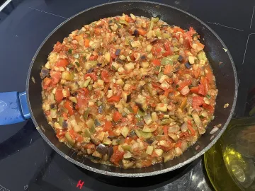 Тушёные кубики кабачков, перца, баклажана и томатов в сковороде