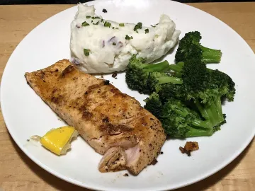 Запечённый лосось с брокколи и картофельным пюре на тарелке