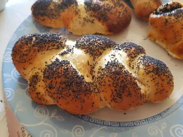 Скрученная булочка с маком на тарелке