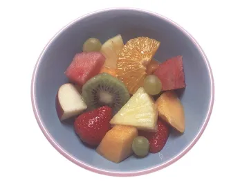 Миска с кусочками фруктов: киви, ананас, клубника, виноград