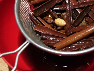 Палочки корицы и миндаль в сите после настаивания