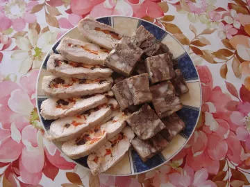 Нарезанный куриный рулет с черносливом и сыром на тарелке