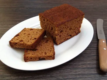 Ржаная медовая коврижка, нарезанная ломтями на белом блюде