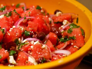 Кубики арбуза с фетой, маслинами и красным луком в миске