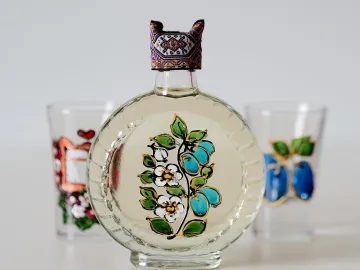 Прозрачная бутылка со сливовым шнапсом и расписными рюмками
