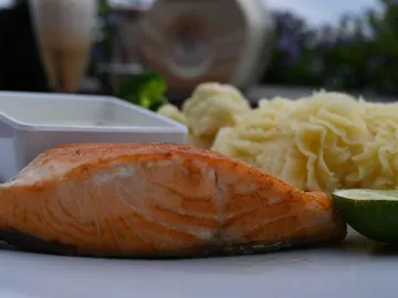 Обжаренный кусок лосося с картофельным пюре и лаймом