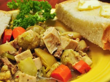 Суп из индейки с брюссельской капустой, морковью и картофелем в жёлтой тарелке