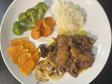 Тарелка с рисом, овощами, тыквой и мясным блюдом