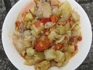 Тушёная курица с капустой, картофелем, морковью и помидорами в белой миске