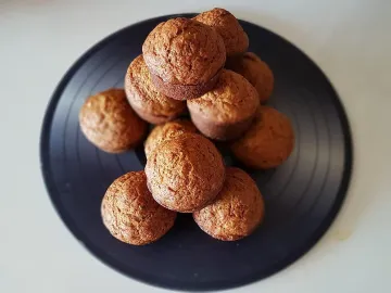 Горка тыквенных маффинов на тёмной круглой тарелке