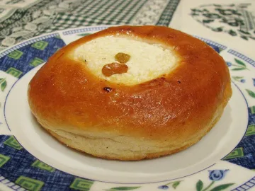 Ватрушка с творогом и изюмом на тарелке