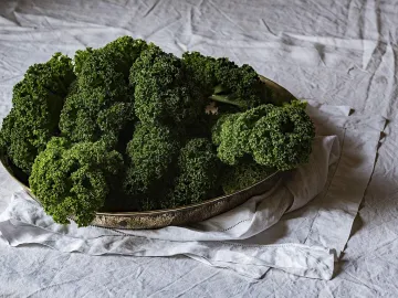 Блюдо с зелёной курчавой капустой кале на льняной скатерти