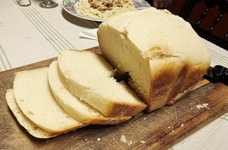 Нарезанный ломтями белый хлеб на деревянной доске