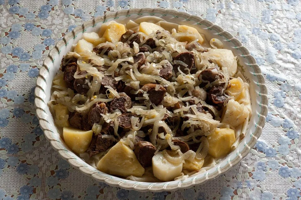 Казахский бешбармак с мясом, картофелем и луком на блюде