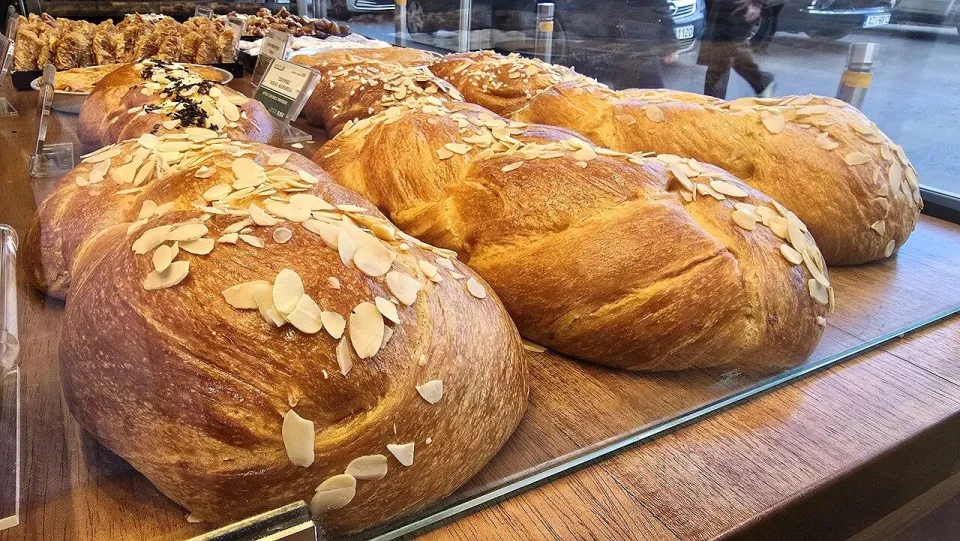 Плетёные греческие цуреки с миндальными лепестками на витрине