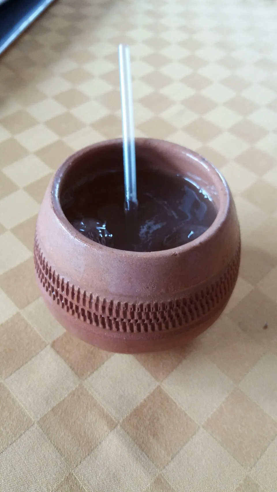 Канчанчара в глиняной чашке с трубочкой на столе