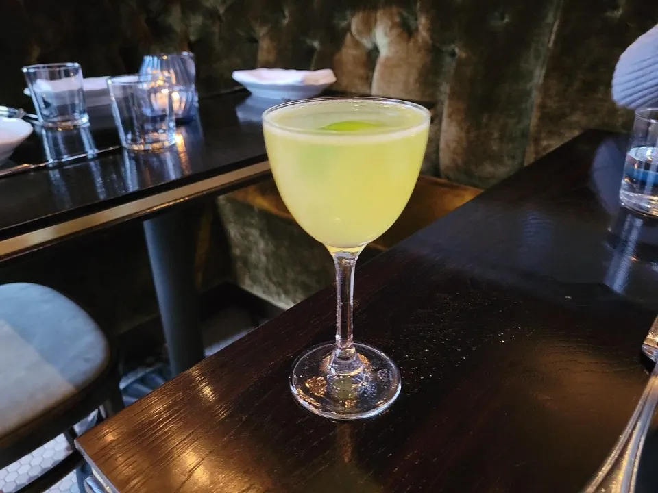 Жёлтый коктейль Йеллоу бёрд в бокале на тонкой ножке